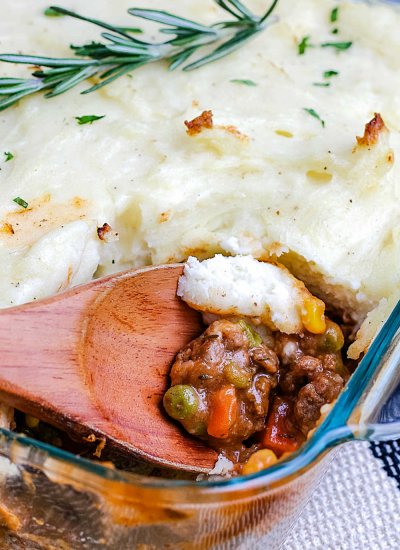 A close up picture of a spoon getting a scoop of shepherd's pie.