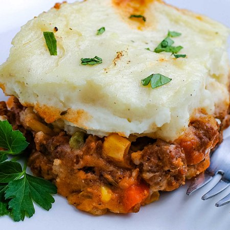 A close up picture of some Shepherd's Pie on a white plate.