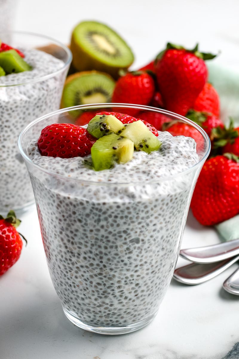Chia Seed Pudding in a glass garnished with chopped strawberries and kiwi.