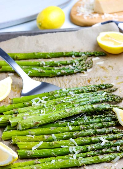 A spatula picking up some roasted asparagus.