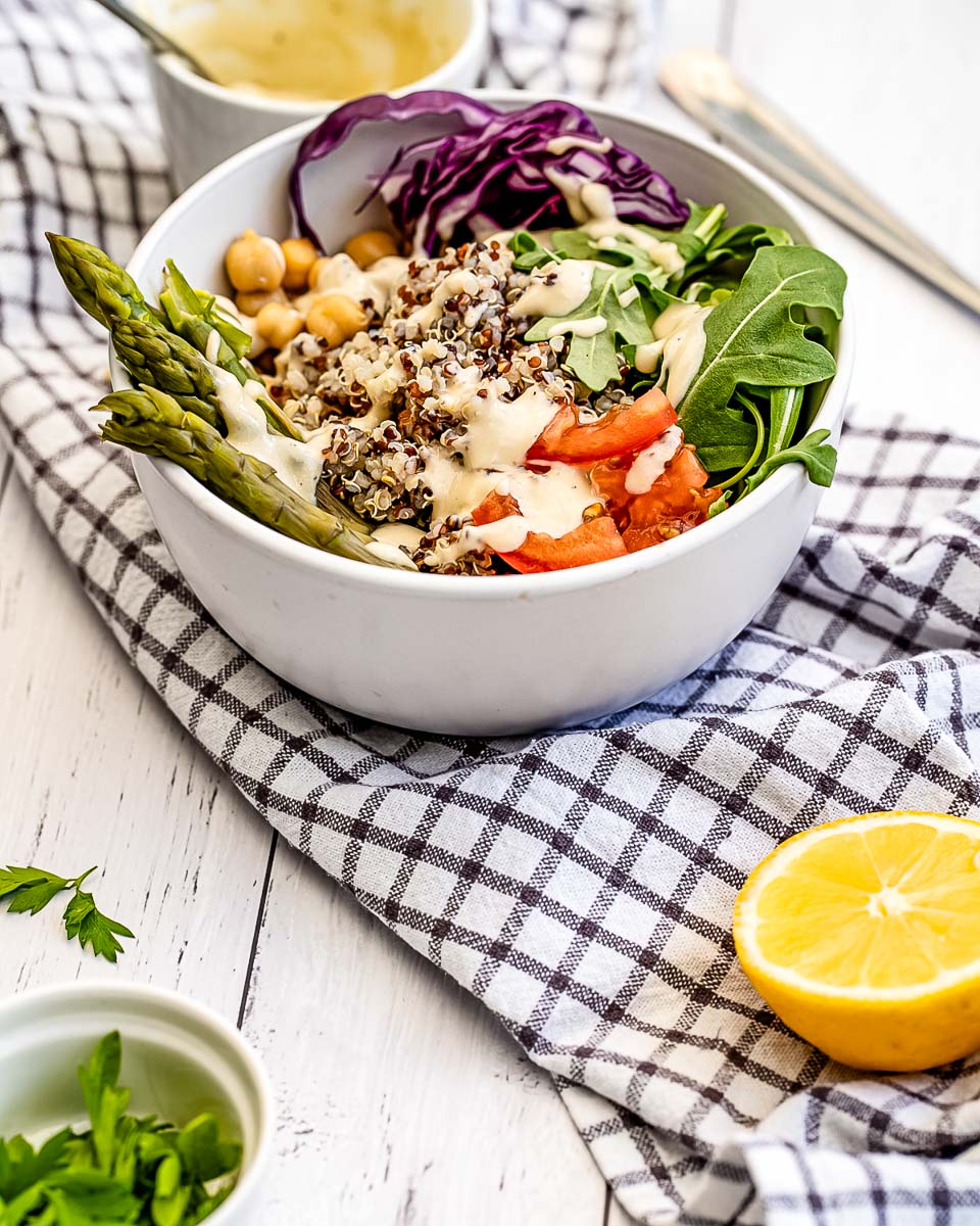 A Buddha Bowl with asparagus, chickpeas, red cabbage, arugula, tomatoes, and quinoa.