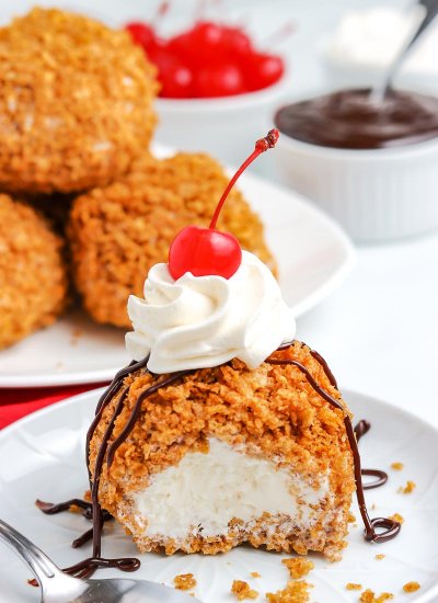 Fried Ice Cream on a white plate with a bite taken out of it.