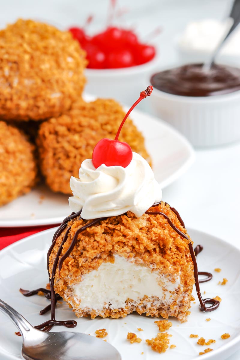 Fried Ice Cream on a white plate with a bite taken out of it. 