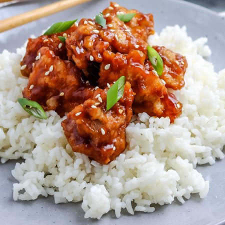 A close up picture of General Tso Chicken on top of rice.