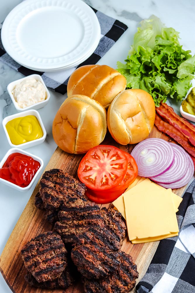 An overhead picture of the finished grilled hamburgers on a white cutting board.