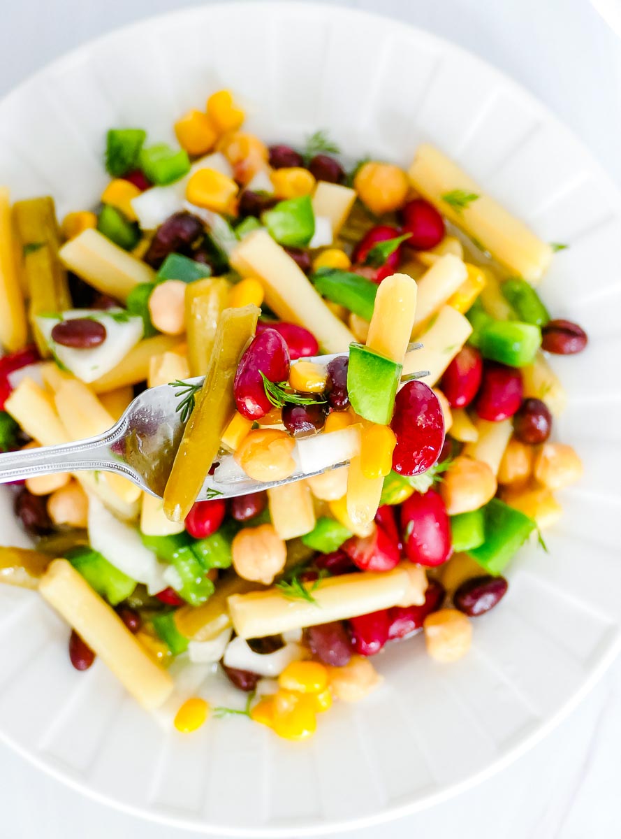 A fork picking up some 5 Bean Salad.
