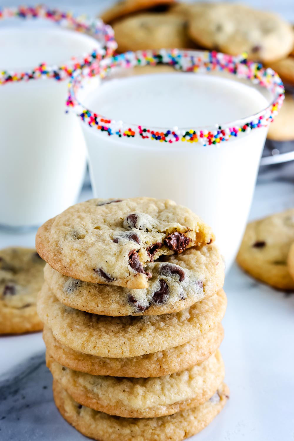 a stack of Copycat Mrs. Field's Chocolate Chip Cookies with a bite taken out of one.
