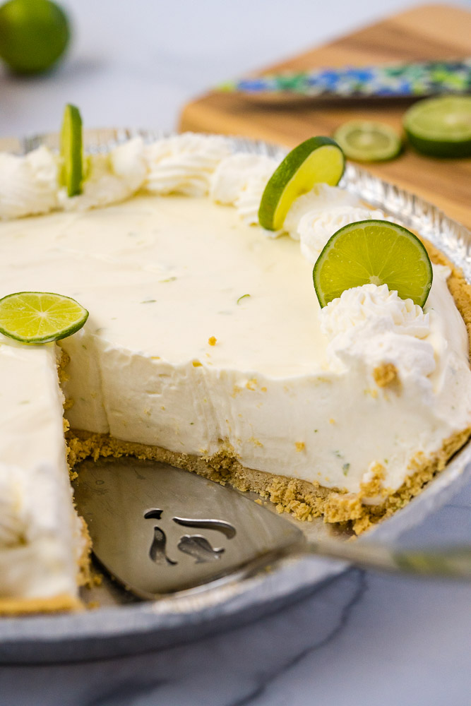 A slice taken out of a key lime pie.
