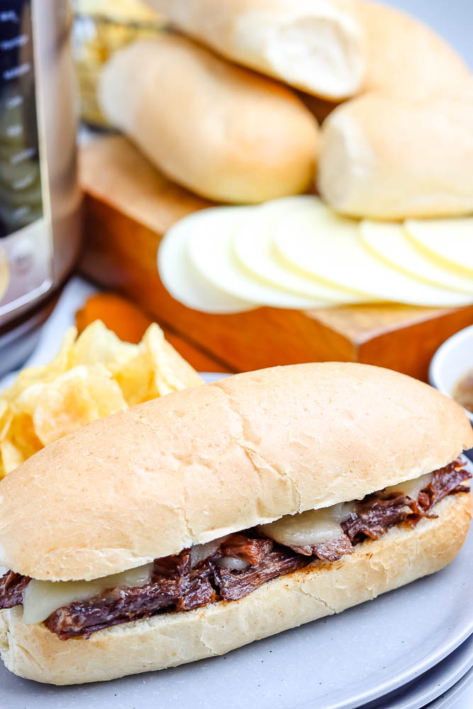 A French Dip Sandwich served on a hoagie roll and with potato chips. 