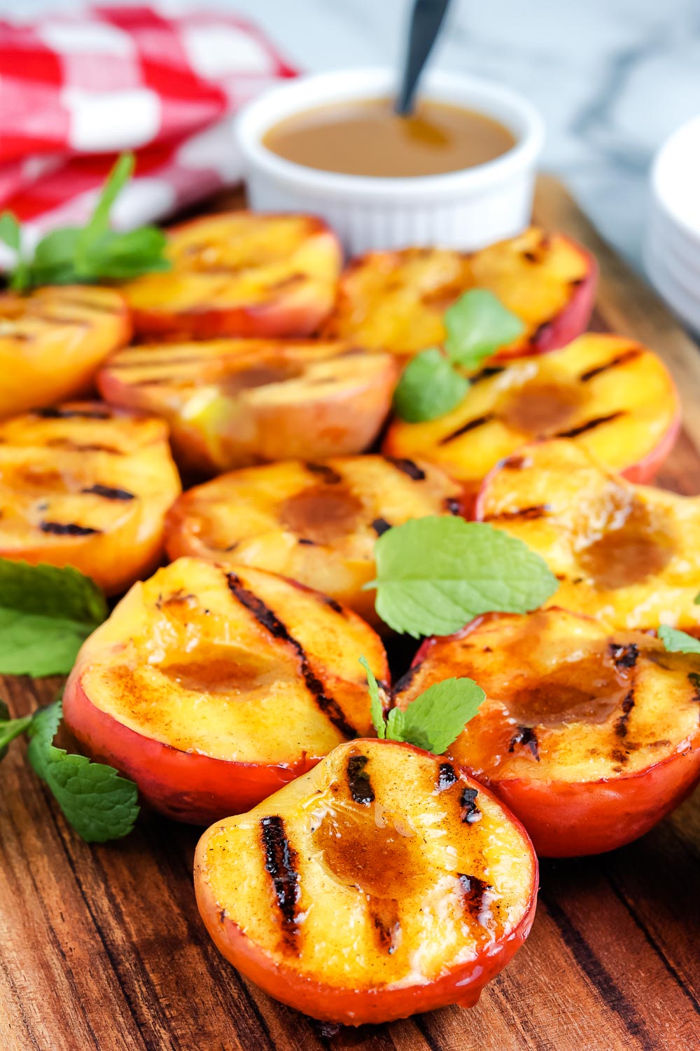 The finished Grilled Peaches on a wooden cutting board.