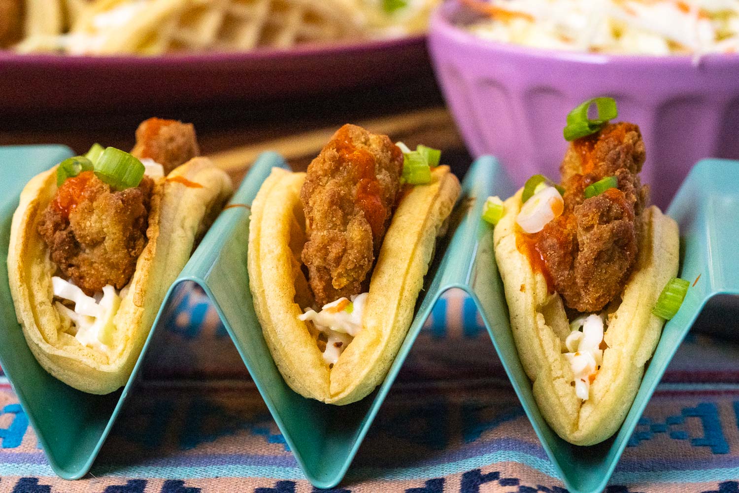 Three waffle tacos in a taco holder.