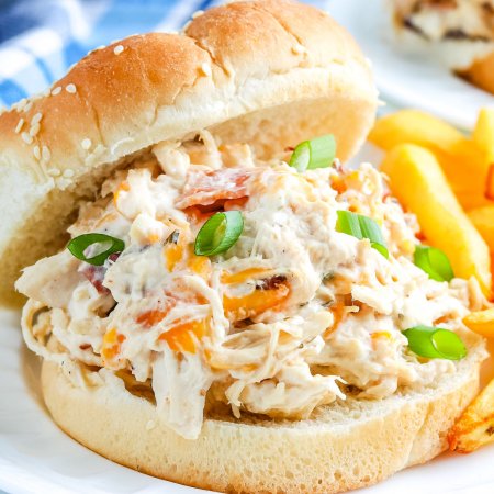 A close up picture of the finished Crockpot Crack Chicken on a hamburger bun.