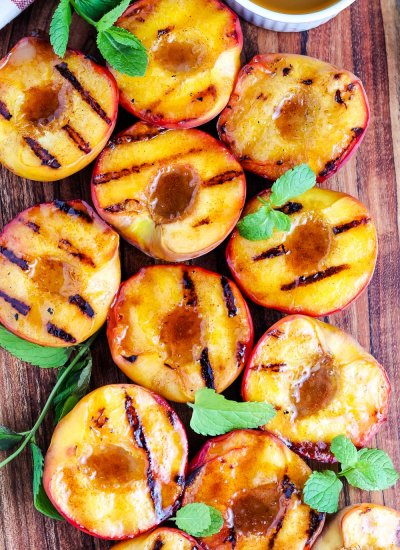 An overhead picture of Grilled Peaches on a wooden cutting board.
