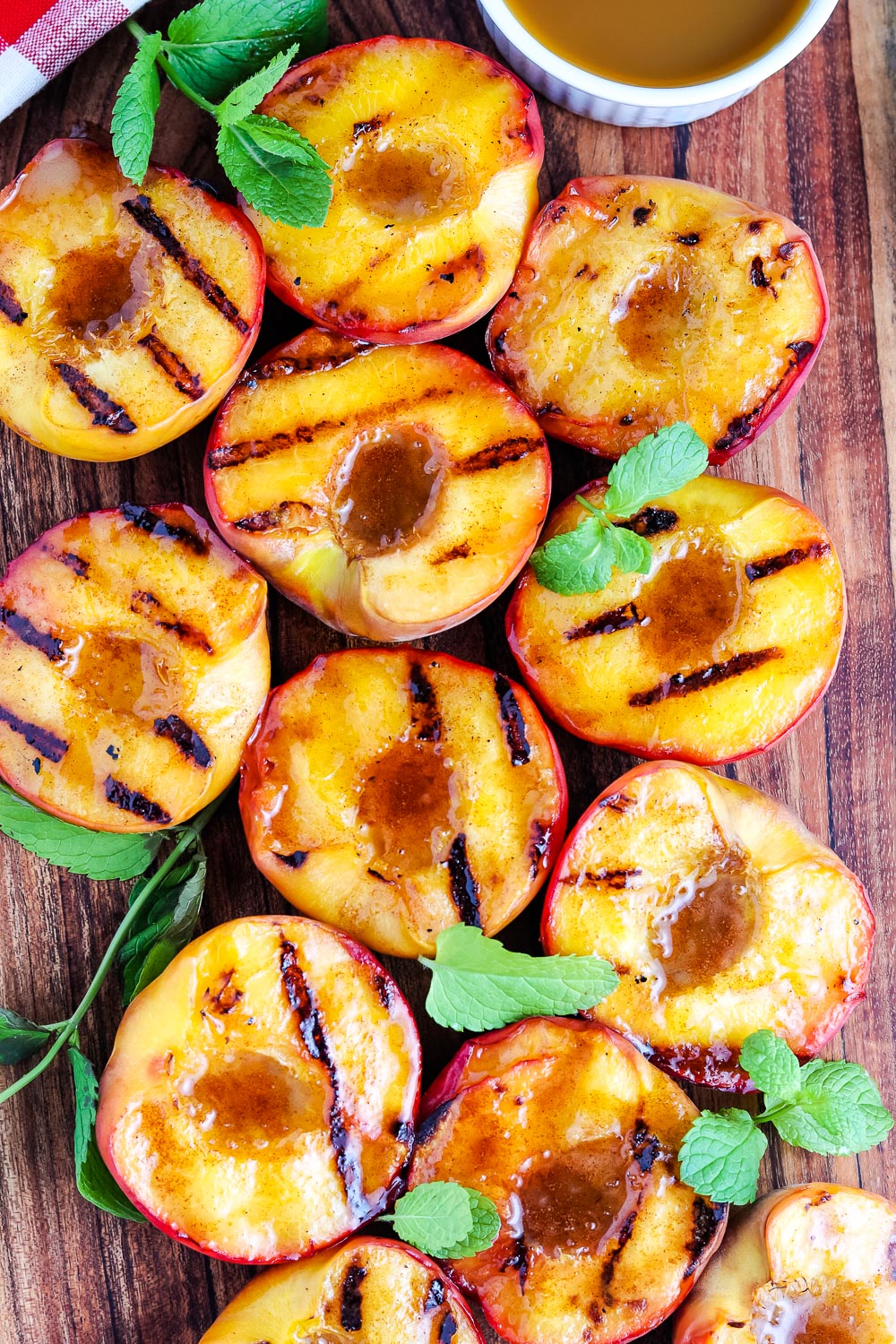 An overhead picture of Grilled Peaches on a wooden cutting board. 