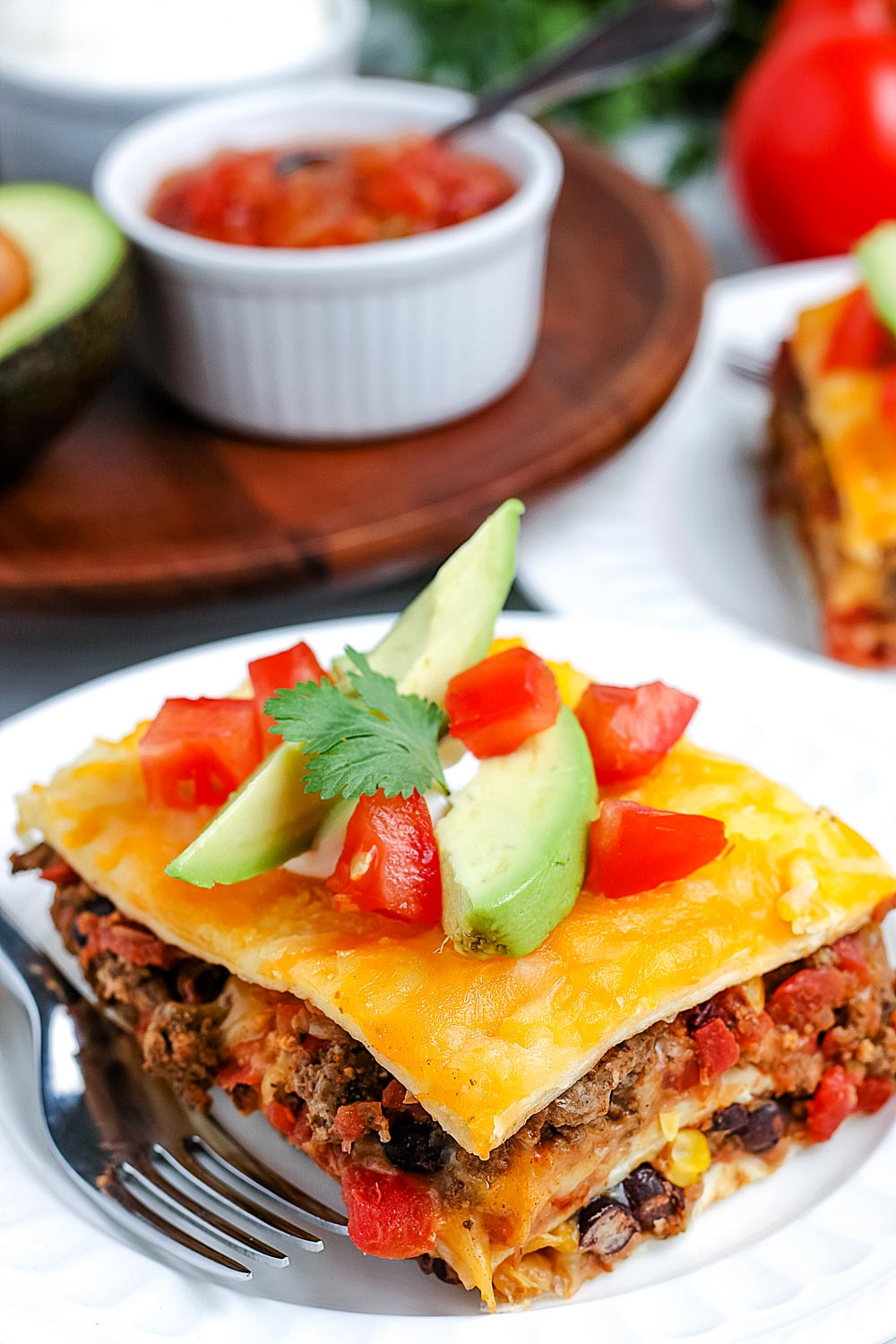 A close up pickets of a slice of Mexican Lasagna made with flour tortillas.