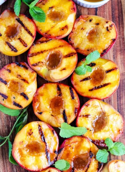 An overhead picture of Grilled Peaches on a wooden cutting board.