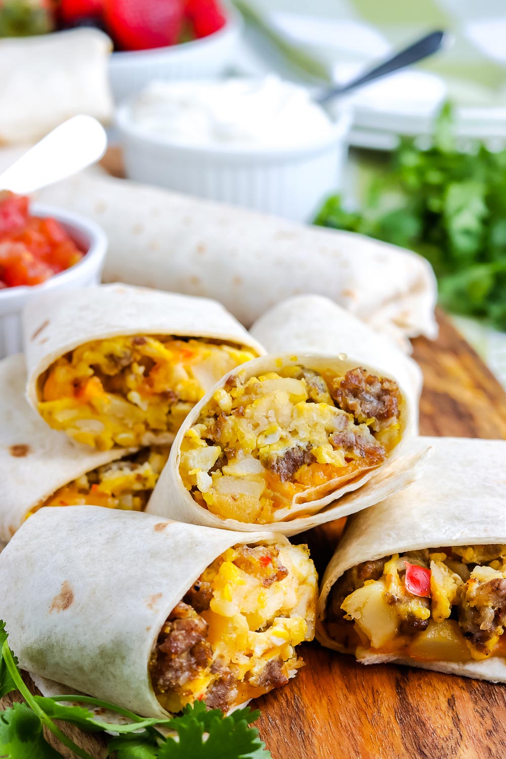 Breakfast Burritos cut in half and on a cutting boar.