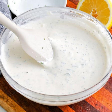 A close up picture of the finished Homemade Ranch Dressing in a clear class mixing bowl.
