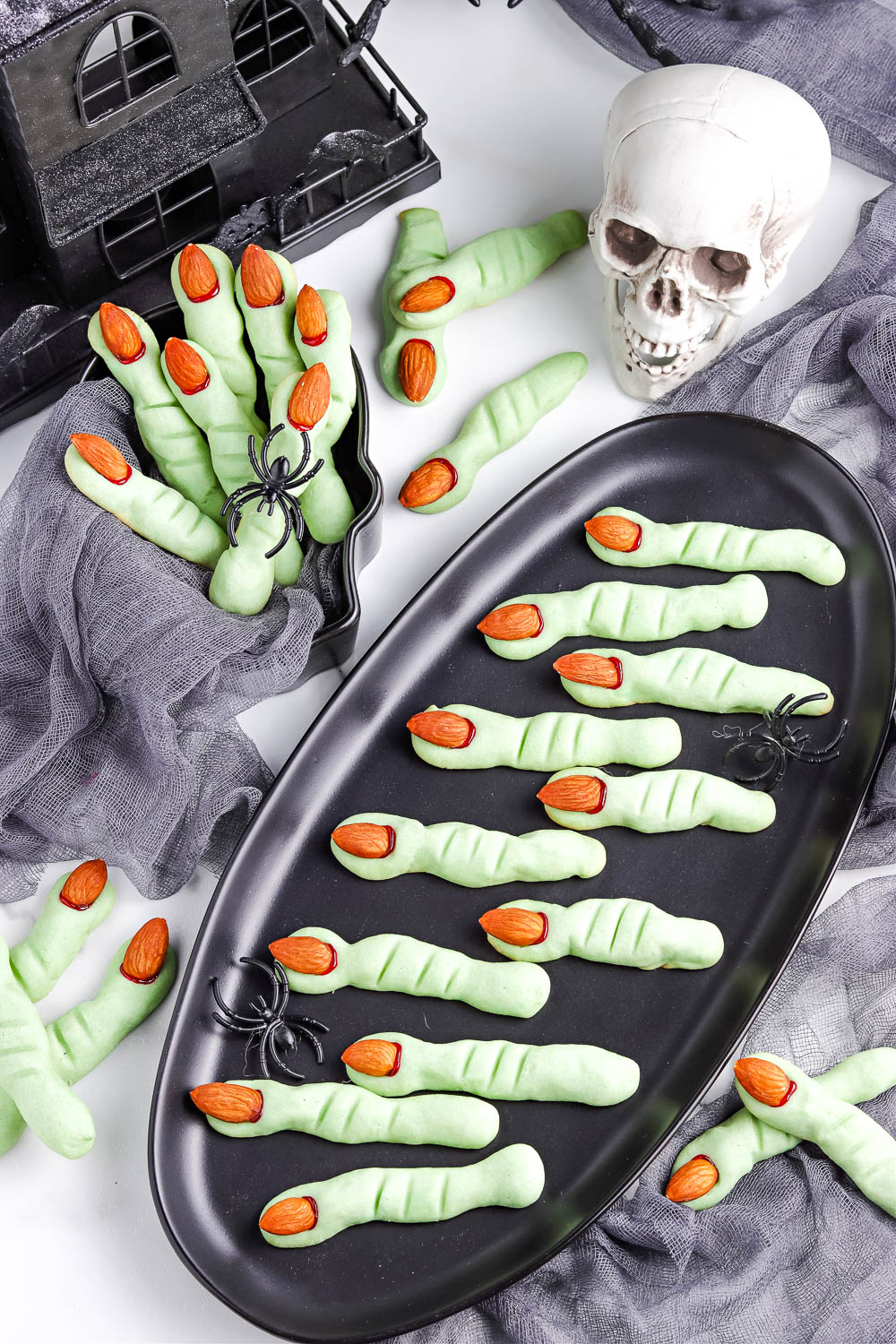 An overhead picture of Witch Finger Cookies on a black platter and in a serving bowl.