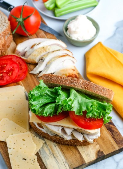 A Leftover Turkey Sandwich on a wooden cutting board.