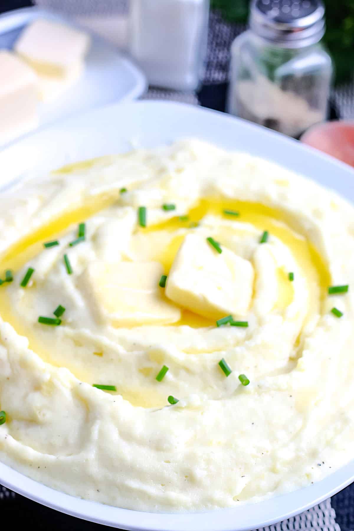a bowl of creamy mashed potatoes with slices of butter on top