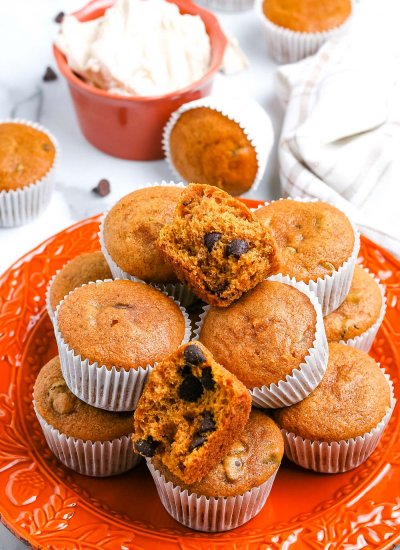 A stack of easy pumpkin muffins on an orange plate.