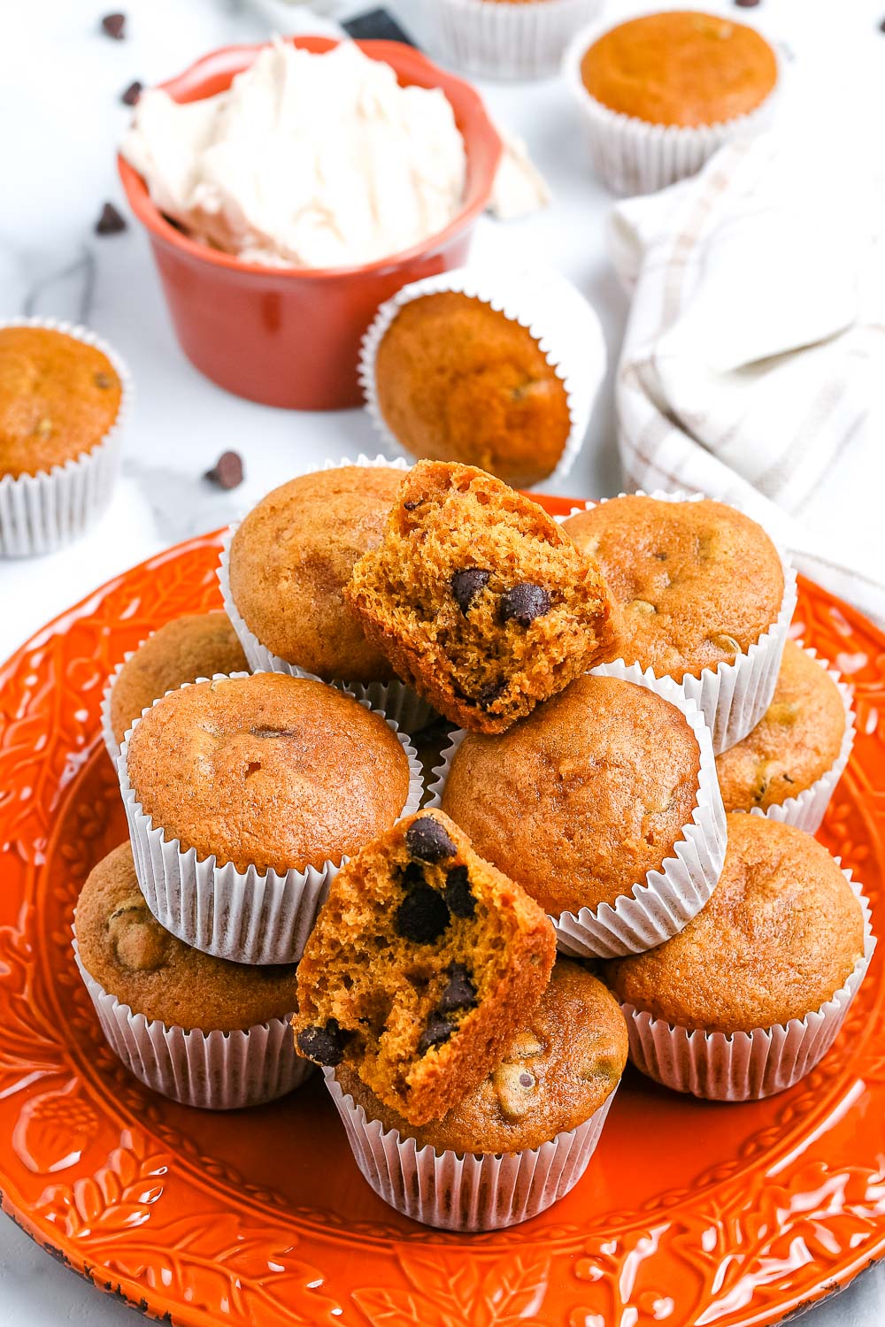 A stack of easy pumpkin muffins on an orange plate. 