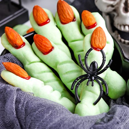 A close up picture of green Witch Finger Cookies in a serving bowl.