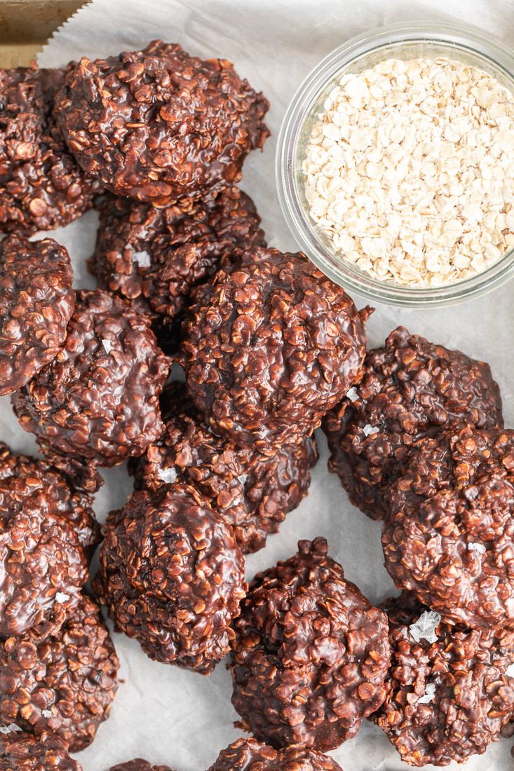 A close up picture of a cluster of the finished No-Bake Chocolate Oat Cookies on a tray with parchment paper.