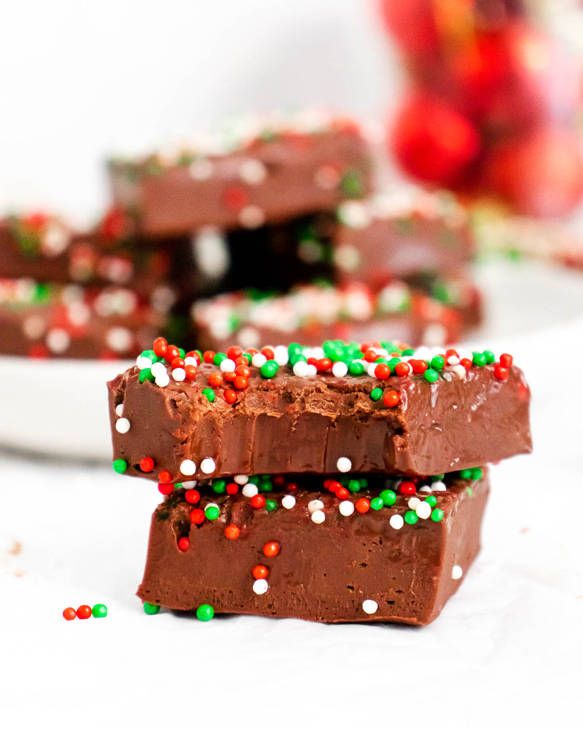 Christmas Fudge stacked on top of each other with a bite taken out of the top one.