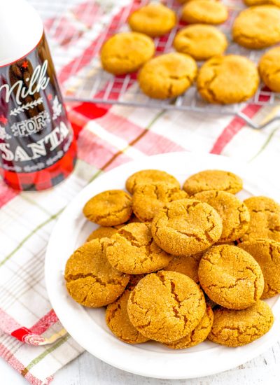 Gingersnap cookies on a plate and some on a wire rack.