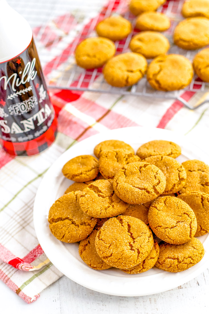 Gingersnap cookies on a plate and some on a wire rack. 