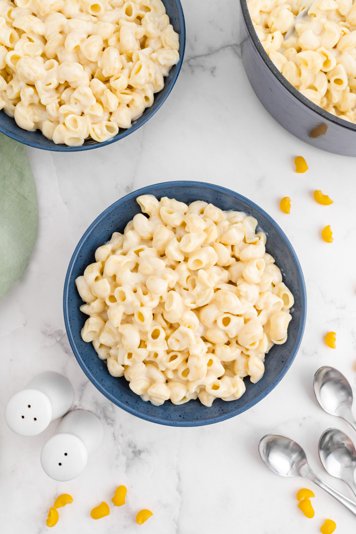 An overhead picture of the finished Panera Mac and Cheese in blue bowls and in the cooking pot. 