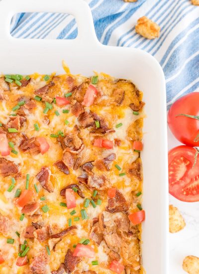 An overhead picture of the finished Tater Tot Breakfast Casserole garnished with tomatoes and green onion.