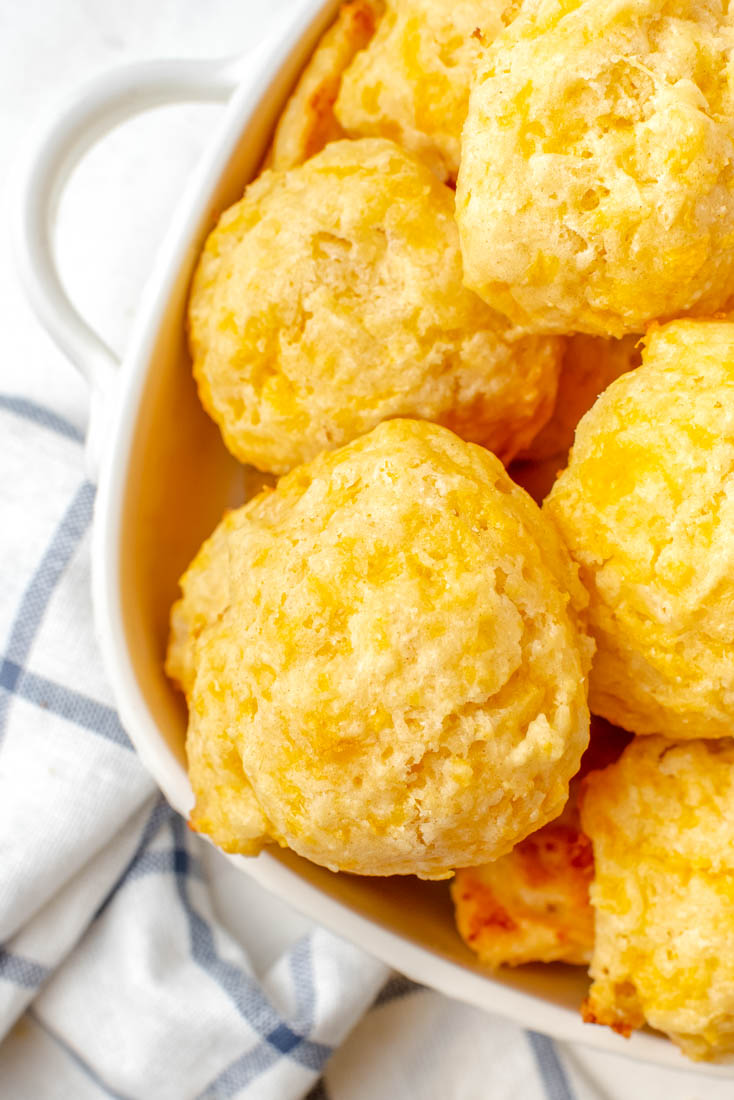 An overhead picture of a bowl full of the finished Cheese Drop Biscuits made from scratch.