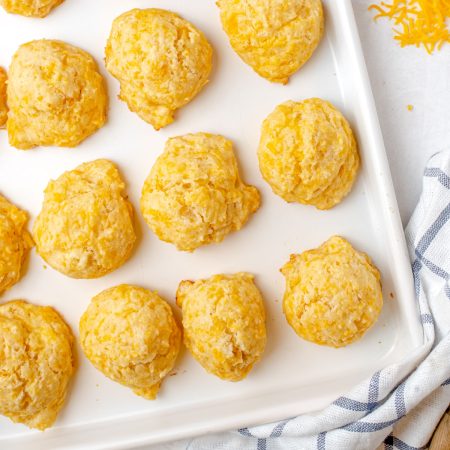 An overhead picture of the finished Cheese Drop Biscuits on a baking sheet.