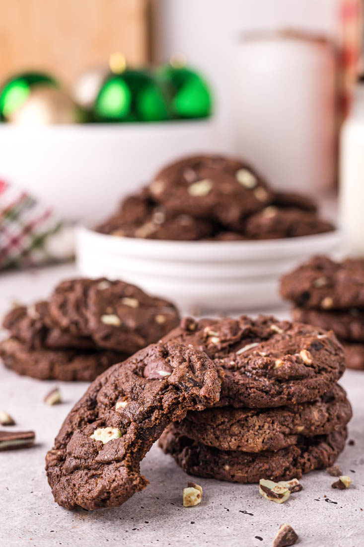 A stack of Chocolate Mint Cookies with a bite taken out of one of them.