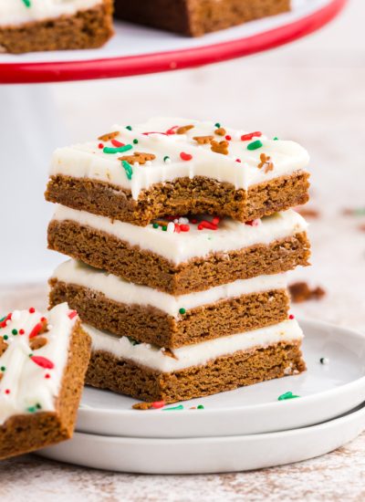 Four gingerbread bars on a plate, and one with a bite taken out of it.
