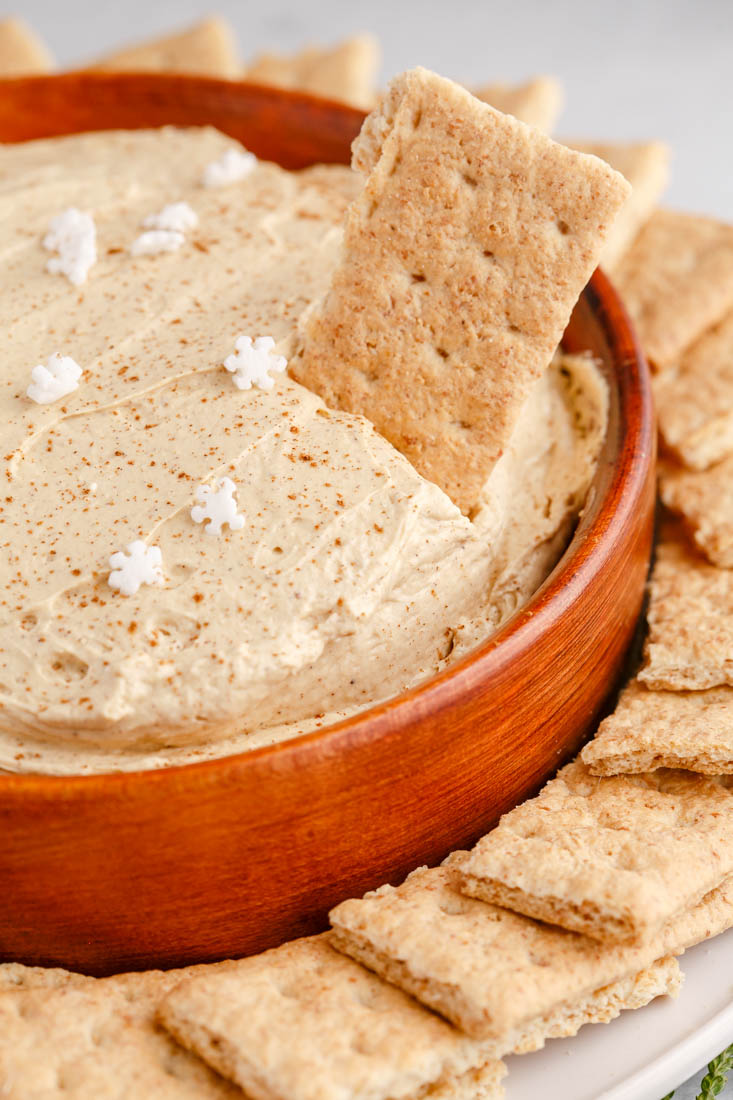 A close up picture of the finished Gingerbread Cheesecake Dip in a wooden serving bowl.