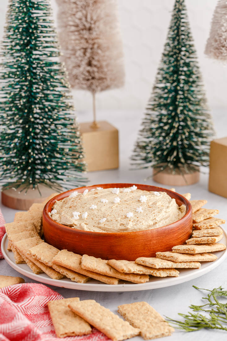 The finished Gingerbread Cheesecake Dip in a wooden serving bowl with graham crackers surrounding it.