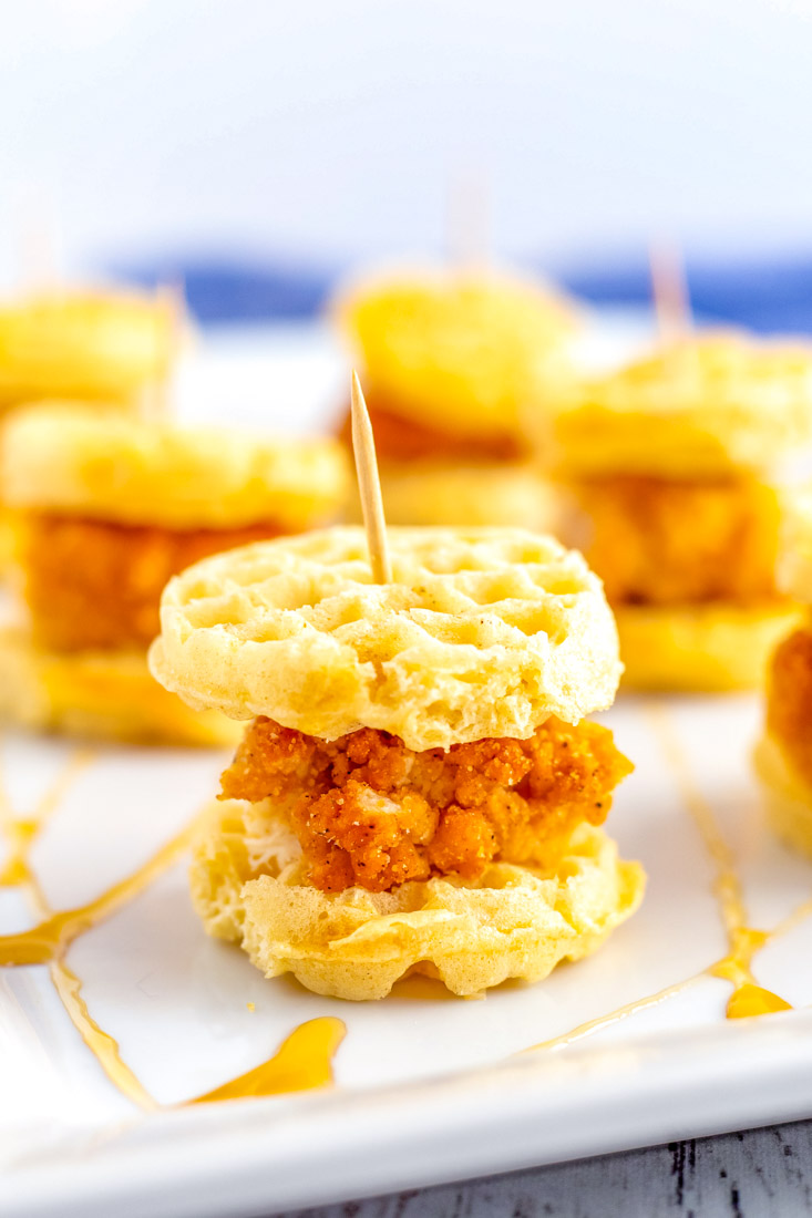 A close up of Chicken and Waffle Sliders on a white serving platter.