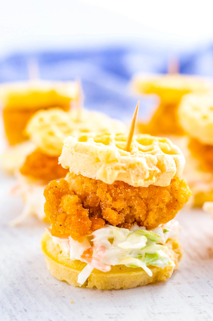 A close up picture of a fnished Chicken and Waffle Sliders with coleslaw on it.
