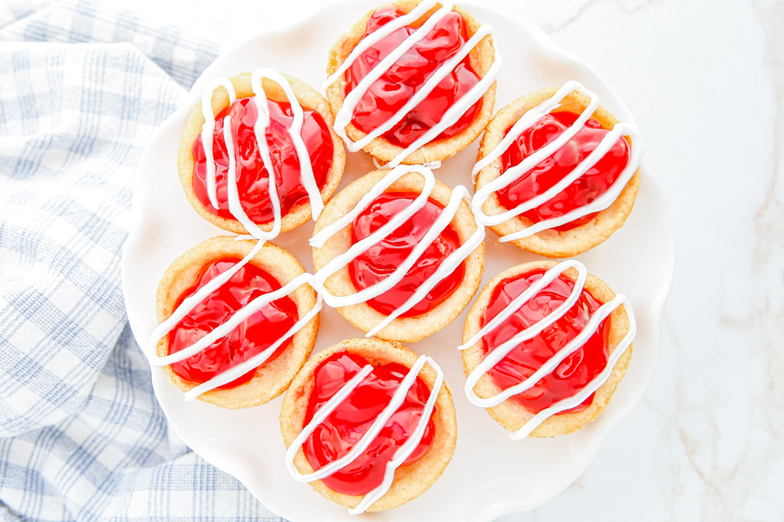 An overhead picture of seven finished Cherry Pie Cookies on a white platter.