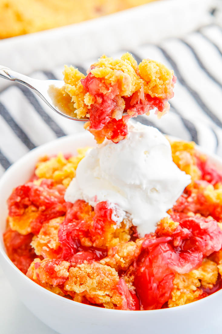 A spoon picking up some of this finished Cherry Pineapple Dump Cake.