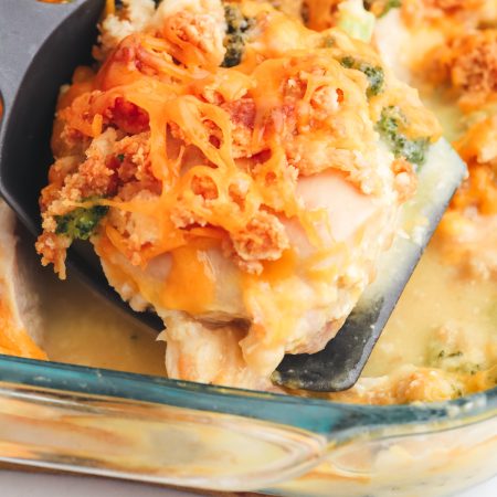 A spatula picking up a piece of the Cracker Barrel Broccoli Cheddar Chicken out of the casserole.