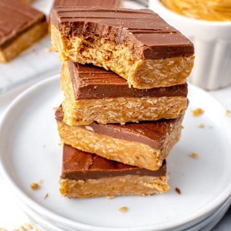A stack of the finished No-Bake Chocolate Peanut Butter Oatmeal Bars on a white plate.