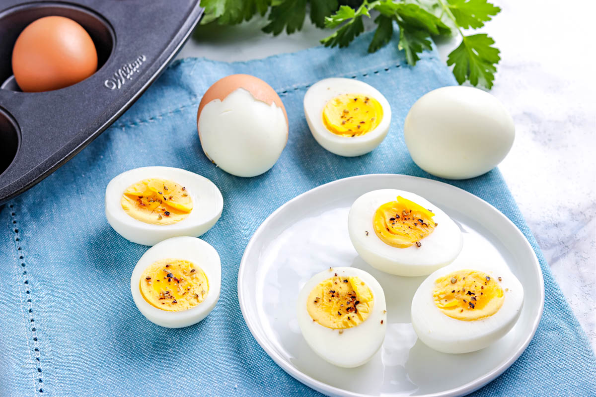 The finished baked eggs that are baked to hard boiled on a white plate.