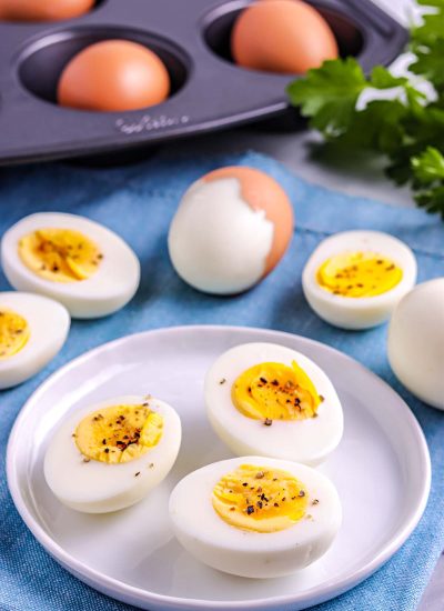the finished Baked Hard Boiled Eggs on a white plate sprinkles with salt and pepper.