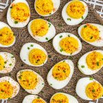 A close up picture of the finished deviled eggs made with horseradish on a wooden platter.