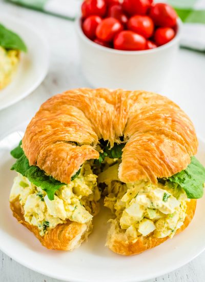 The finished egg salad sandwich recipe on a white plate.